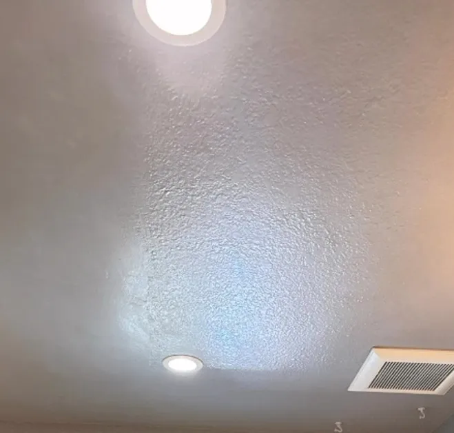 The same bathroom ceiling after cleaning, bright and spot-free