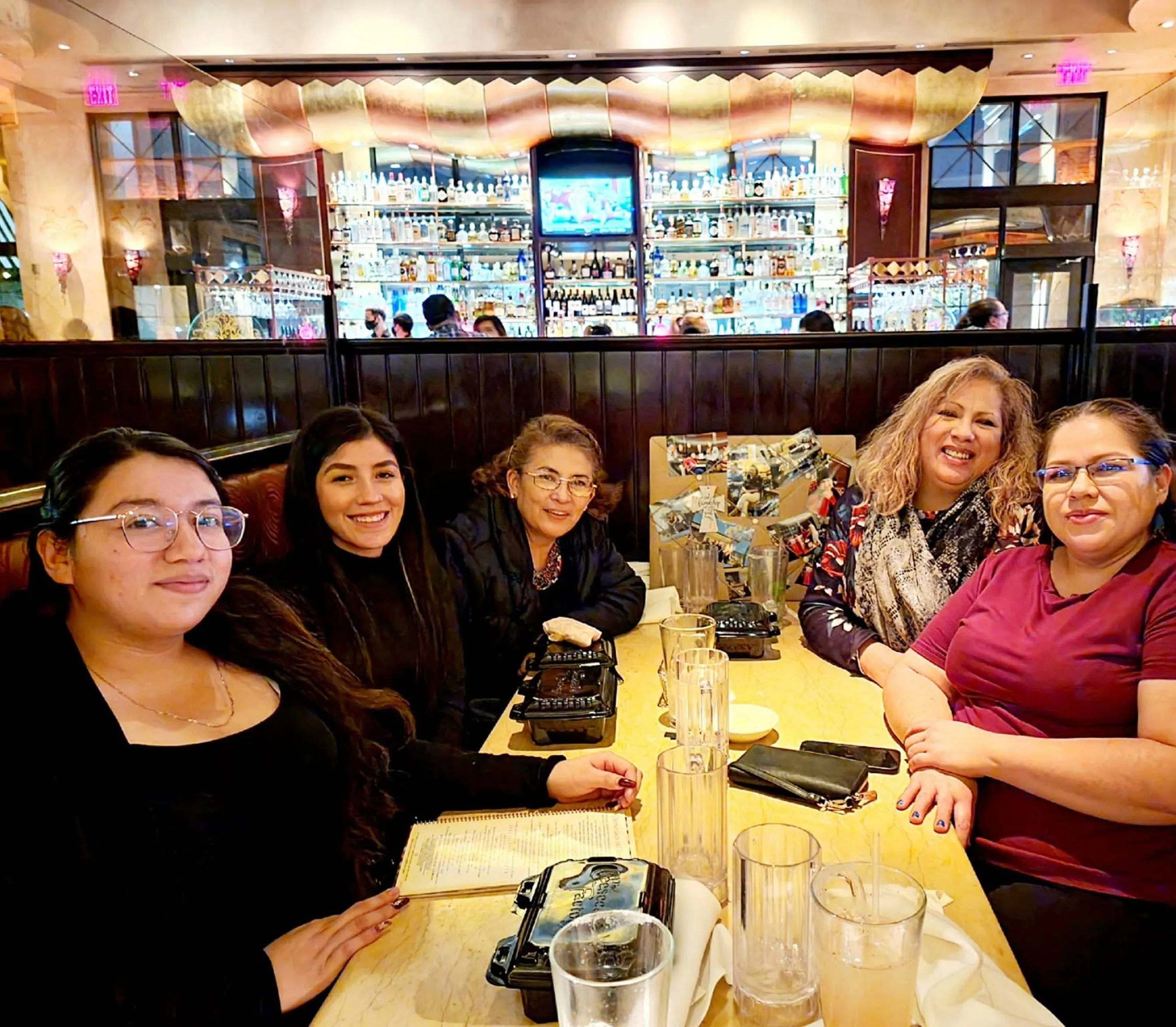 Adeline and members of the Sweet Adeline's team smiling together at a restaurant table